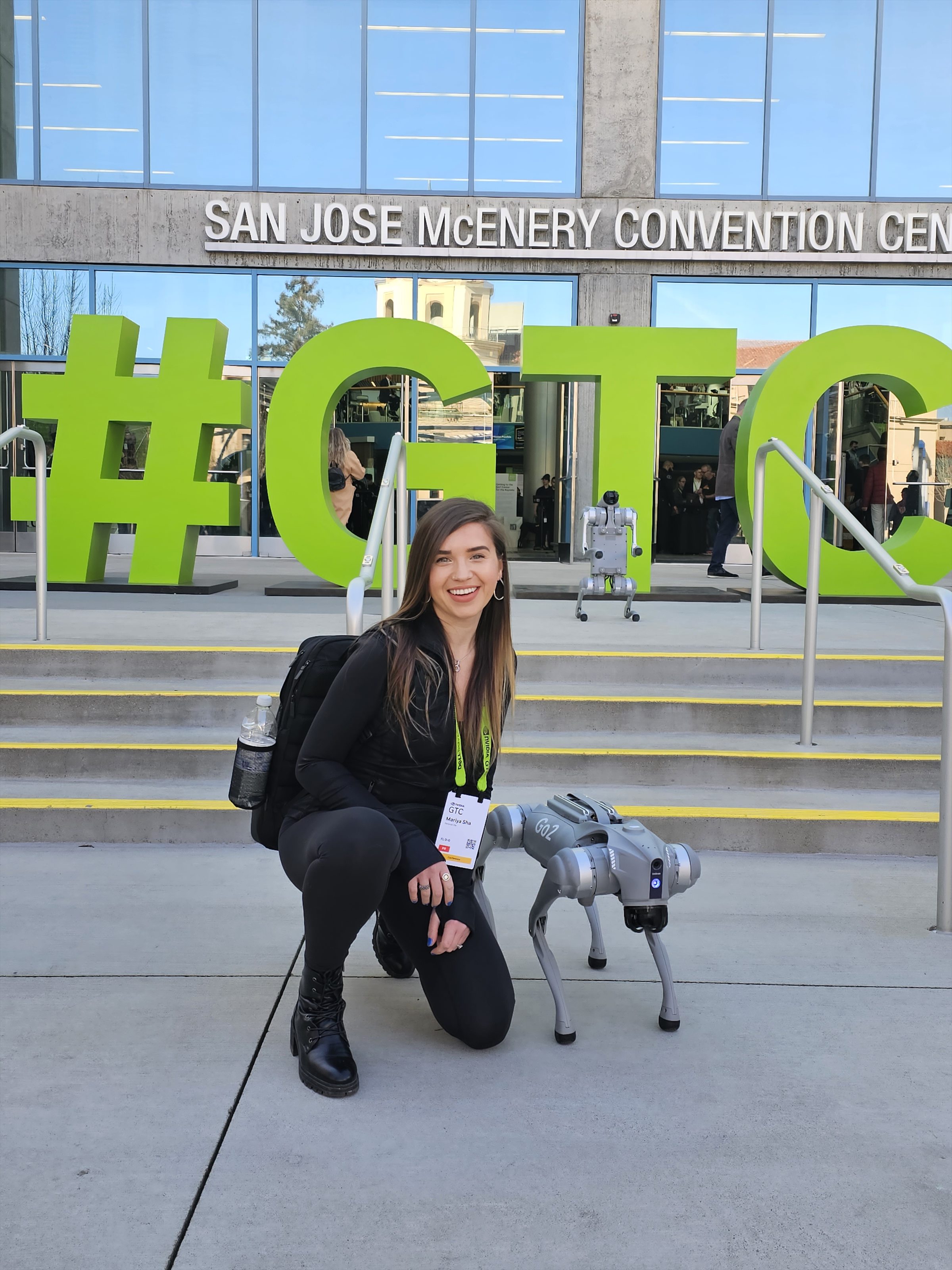Mariya Sha with a robot dog outside GTC